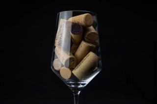 Bouteille de vin rebouchée posée à côté d'un verre sur une table